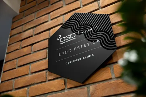 Wnętrze EndoEstetica Clinic: szyld kliniki na ceglanej elewacji